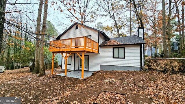 rear view of property featuring a deck and a patio