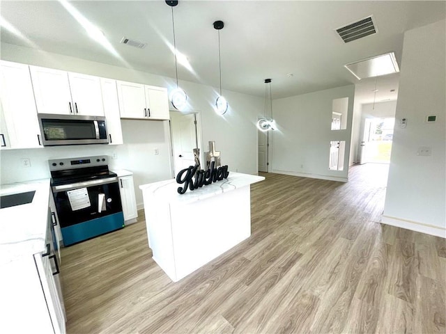 kitchen with white cabinetry, visible vents, light wood finished floors, and appliances with stainless steel finishes