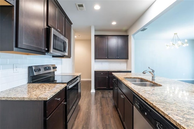 382 Mulberry Row SE, Atlanta, GA 30354 - kitchen featuring appliances with stainless steel finishes, dark wood finished floors, dark brown cabinetry, light stone countertops, and recessed lighting
