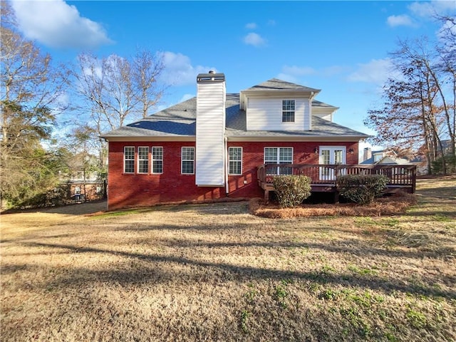 rear view of property featuring a yard and a deck