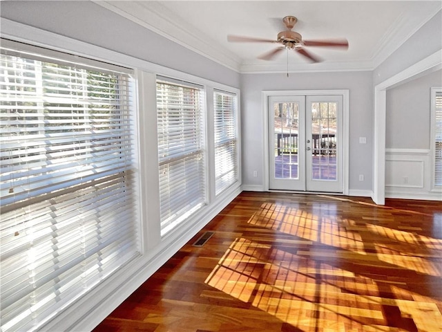 unfurnished sunroom with ceiling fan, a healthy amount of sunlight, and french doors