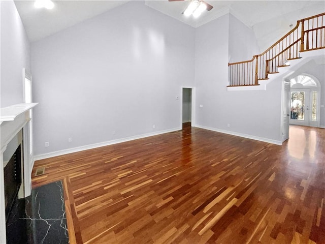 unfurnished living room featuring french doors, ceiling fan, dark hardwood / wood-style flooring, and a high ceiling