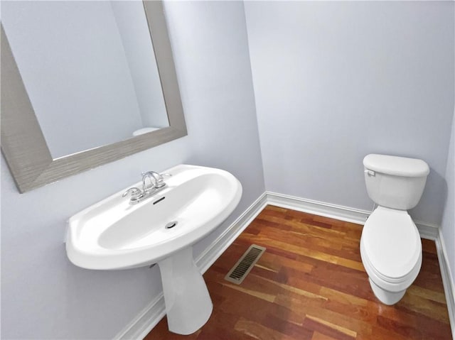 bathroom featuring hardwood / wood-style flooring and toilet