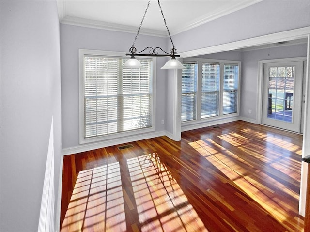 unfurnished dining area with a healthy amount of sunlight, ornamental molding, and wood-type flooring