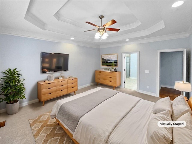 bedroom with connected bathroom, a tray ceiling, ceiling fan, crown molding, and carpet floors