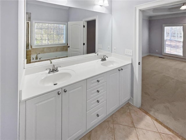 bathroom featuring tile patterned flooring, vanity, a healthy amount of sunlight, and a tub to relax in