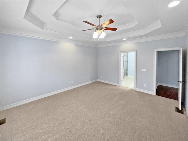 carpeted empty room featuring a raised ceiling, ceiling fan, and ornamental molding