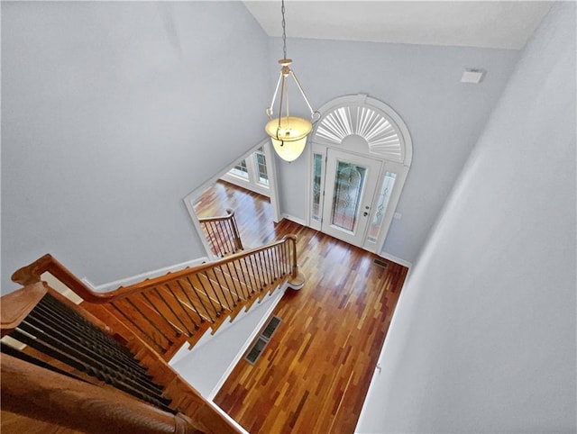 foyer entrance featuring wood-type flooring and lofted ceiling