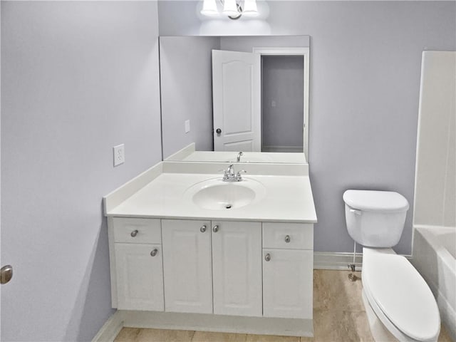 bathroom featuring a tub, vanity, and toilet