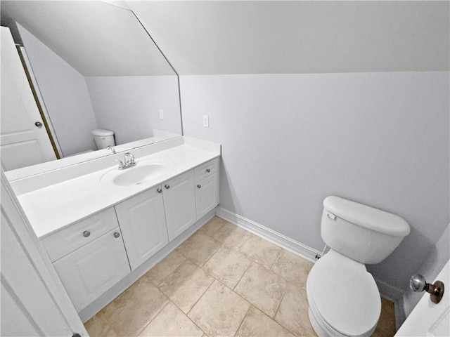 bathroom with vanity, toilet, and vaulted ceiling