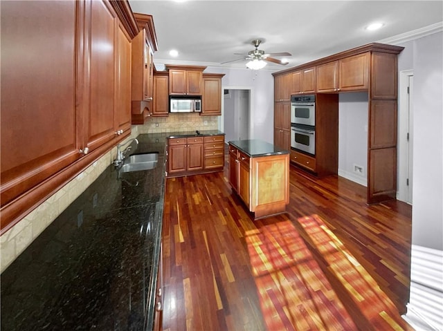 kitchen featuring appliances with stainless steel finishes, backsplash, crown molding, sink, and dark stone countertops