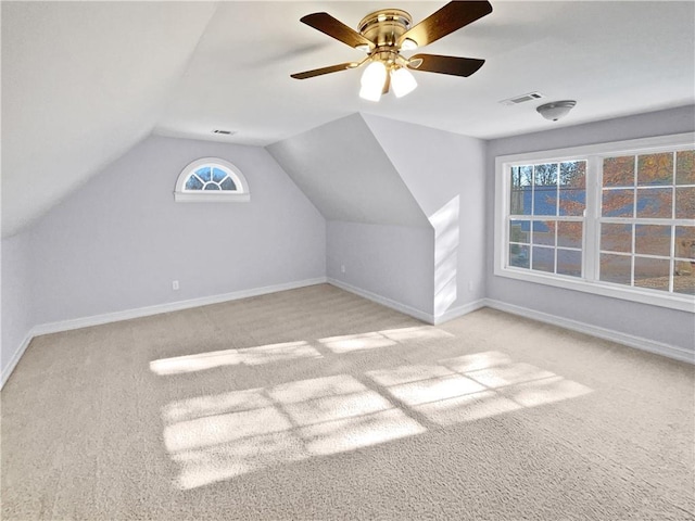 additional living space featuring a wealth of natural light, ceiling fan, light carpet, and lofted ceiling