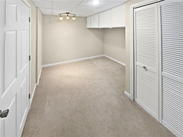 basement with light carpet and a drop ceiling