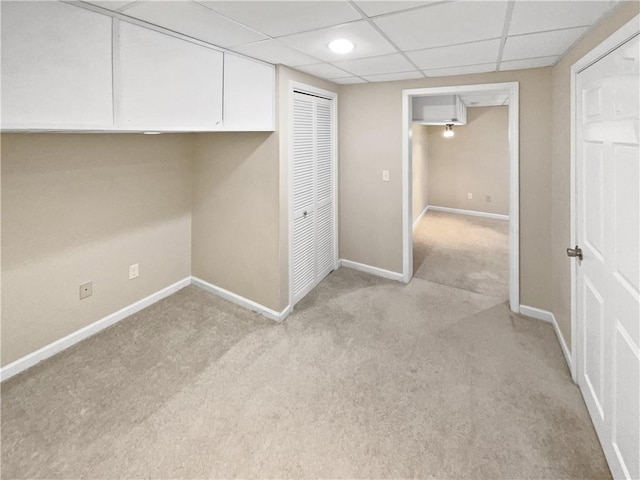 interior space featuring a paneled ceiling and light carpet