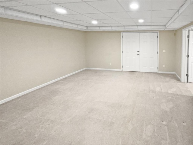 unfurnished bedroom featuring light carpet and a paneled ceiling