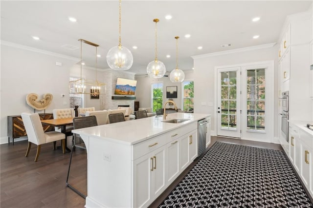427 Burton Dr, Alpharetta, GA 30009 - kitchen featuring a sink, ornamental molding, appliances with stainless steel finishes, a center island with sink, and light countertops