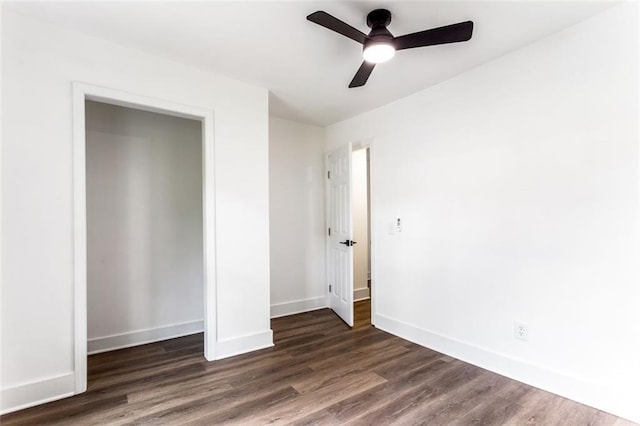 unfurnished bedroom featuring dark hardwood / wood-style flooring, ceiling fan, and a closet