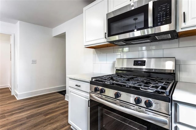 kitchen with white cabinets, stainless steel appliances, backsplash, and dark hardwood / wood-style flooring