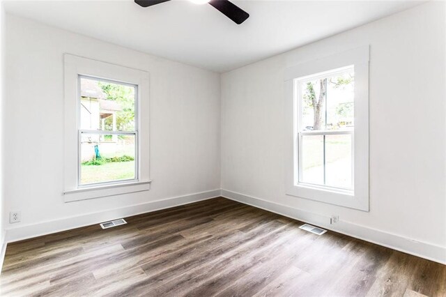 empty room with ceiling fan, plenty of natural light, and wood-type flooring