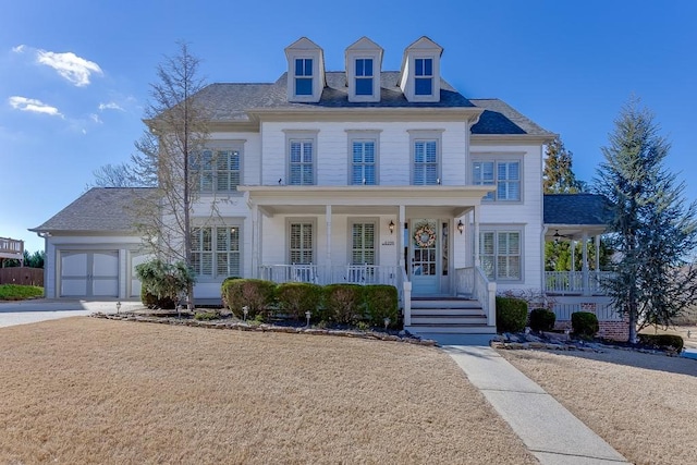 view of front of property featuring a porch, driveway, and a garage