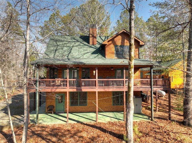 back of house featuring a wooden deck and a patio area