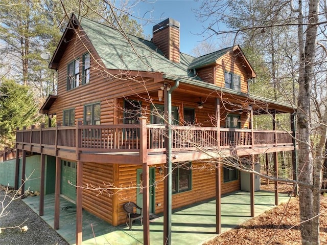 rear view of house featuring ceiling fan and a deck