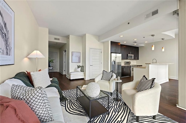 living room with dark hardwood / wood-style flooring and sink