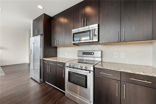 kitchen featuring tasteful backsplash, dark brown cabinets, dark wood-type flooring, and stainless steel appliances