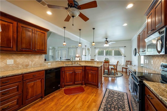 815 Spring View Ct, Covington, GA 30014 - kitchen featuring appliances with stainless steel finishes, a sink, ceiling fan, light wood finished floors, and a peninsula