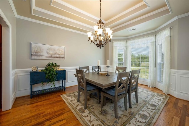 815 Spring View Ct, Covington, GA 30014 - dining room with a tray ceiling, a chandelier, wainscoting, wood finished floors, and ornamental molding