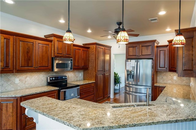 815 Spring View Ct, Covington, GA 30014 - kitchen with appliances with stainless steel finishes, a peninsula, a ceiling fan, light stone counters, and ornamental molding