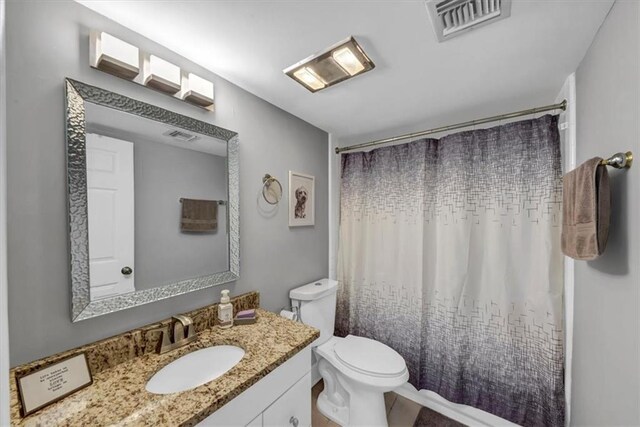 bathroom with toilet, vanity, and a shower with shower curtain