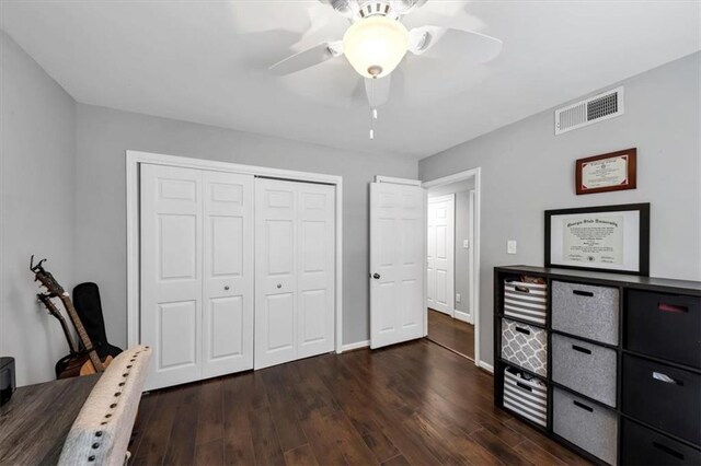 bedroom with a closet, dark hardwood / wood-style floors, and ceiling fan