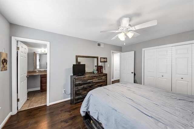 bedroom with connected bathroom, a closet, dark wood-type flooring, and ceiling fan