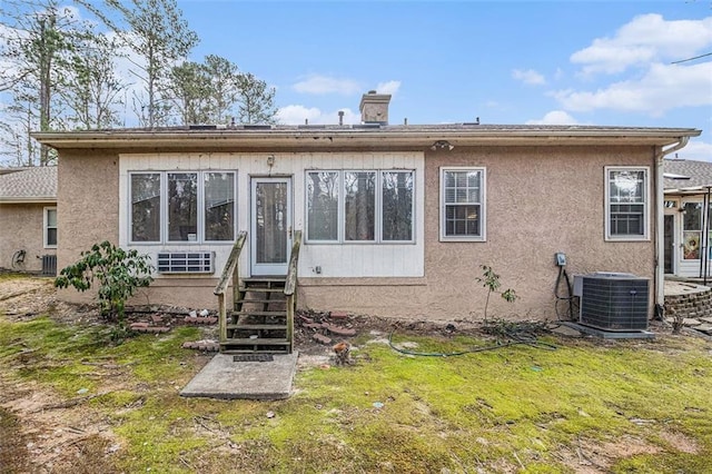 back of property with a yard and central AC unit