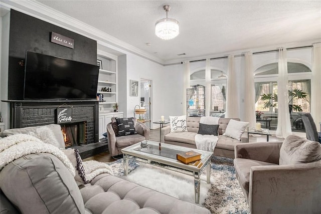 living room featuring built in features, ornamental molding, hardwood / wood-style floors, and a brick fireplace