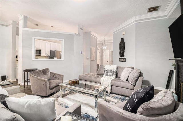 living room featuring crown molding, an inviting chandelier, and wood-type flooring