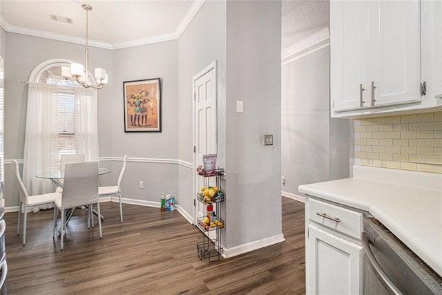 dining room with dark hardwood / wood-style flooring, ornamental molding, and an inviting chandelier