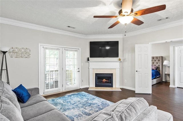 living room featuring dark hardwood / wood-style floors, a textured ceiling, and ornamental molding