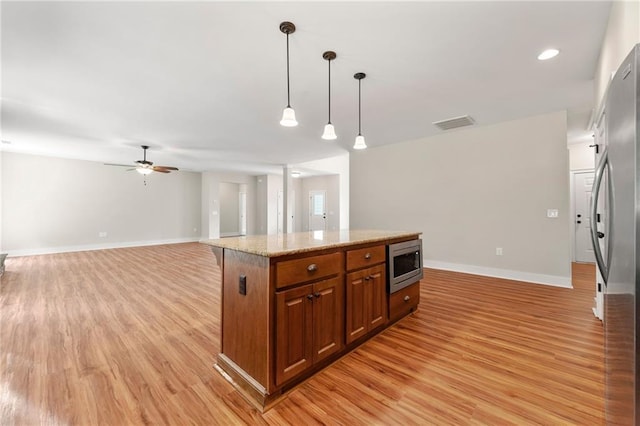 kitchen with appliances with stainless steel finishes, brown cabinets, light wood-style floors, baseboards, and recessed lighting