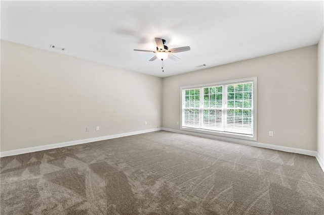 carpeted empty room with a ceiling fan and baseboards