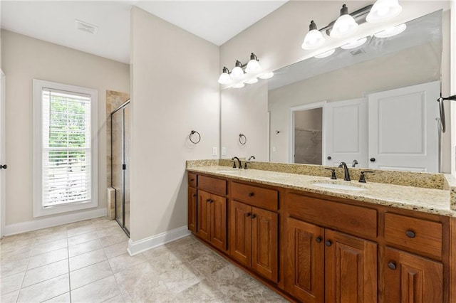 bathroom featuring baseboards, a stall shower, double vanity, and tile patterned floors