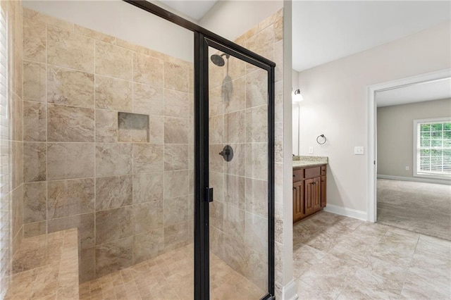 full bath with a shower stall, vanity, and baseboards