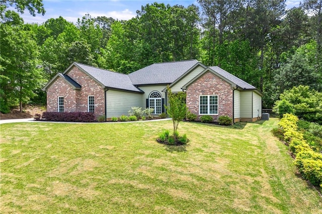 single story home with brick siding, a front yard, and cooling unit