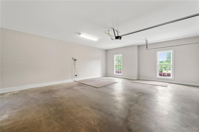 garage featuring a garage door opener and baseboards