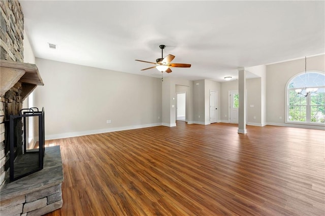 unfurnished living room featuring wood finished floors, a fireplace, a ceiling fan, and baseboards