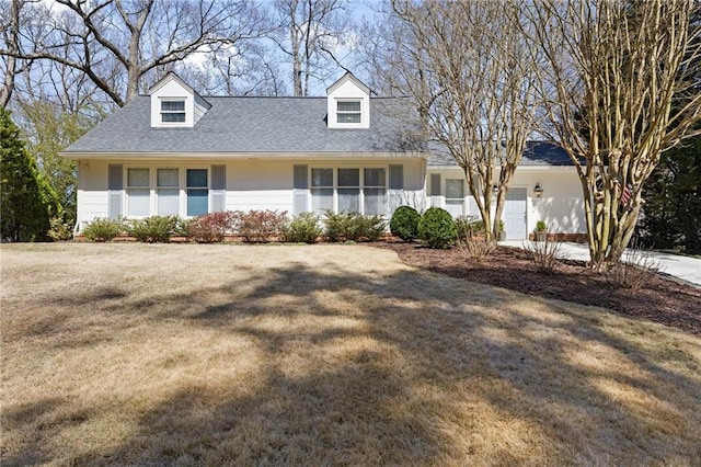 cape cod house featuring a front lawn and roof with shingles