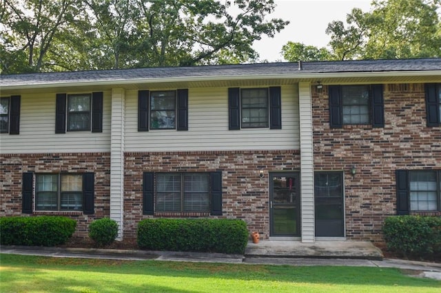 view of front of property featuring a front yard and brick siding