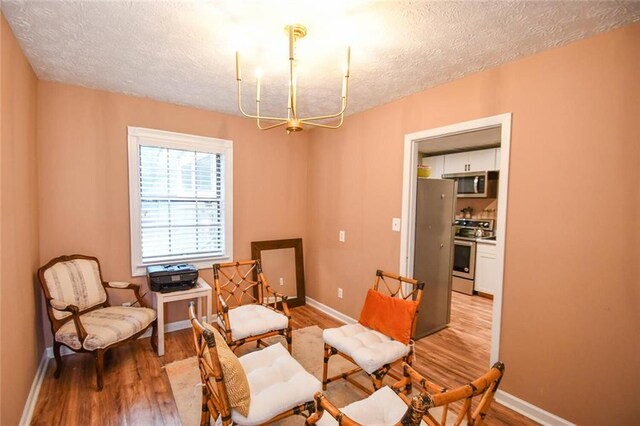 1235 Riverside Dr Unit H3, Gainesville, GA 30501 - sitting room with an inviting chandelier, a textured ceiling, baseboards, and wood finished floors