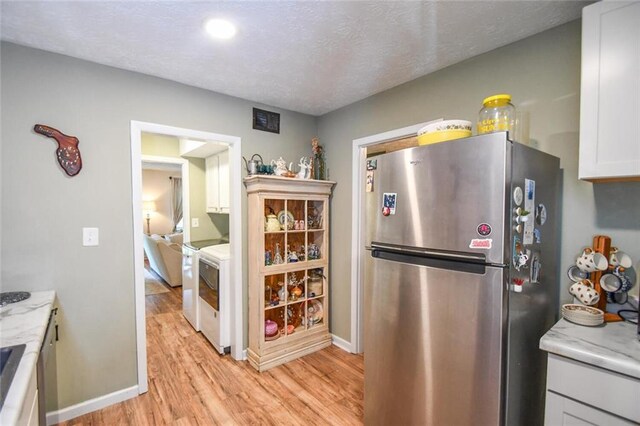 1235 Riverside Dr Unit H3, Gainesville, GA 30501 - kitchen with light countertops, light wood-style floors, freestanding refrigerator, and white cabinets